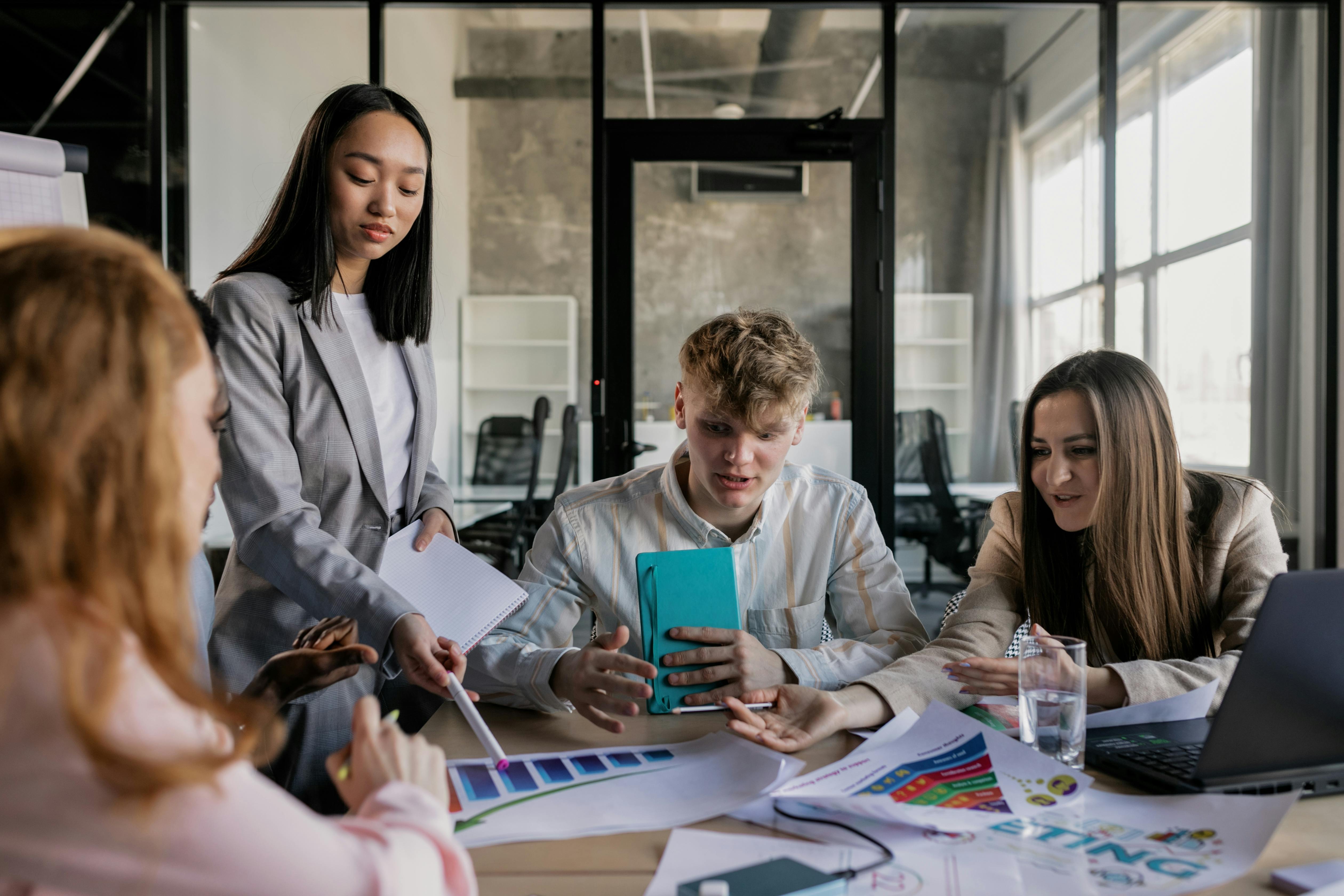 A diverse group of colleagues having a lively discussion around a conference table in a modern office.